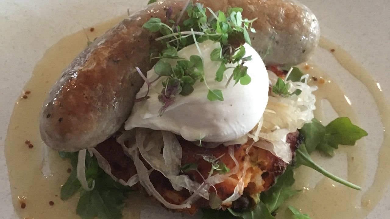 Breakfast at The Gunshop Cafe. Pork, apple & sage sausage, bubble & squeak rosti, sauerkraut, honey mustard dressing, and a poached egg.